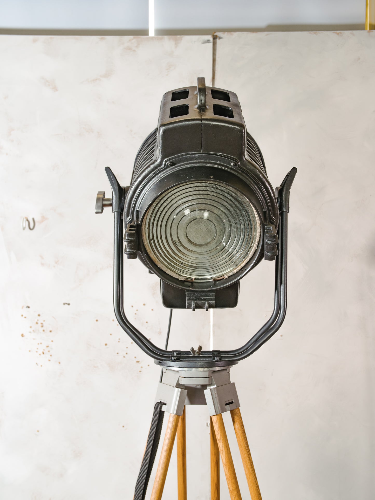 Vintage ARRI Arnold & Richter 2KW filmspot uit de jaren 50 op houten statief, industriële Hollywood-theatervloerlamp, Fresnel-podiumverlichting
