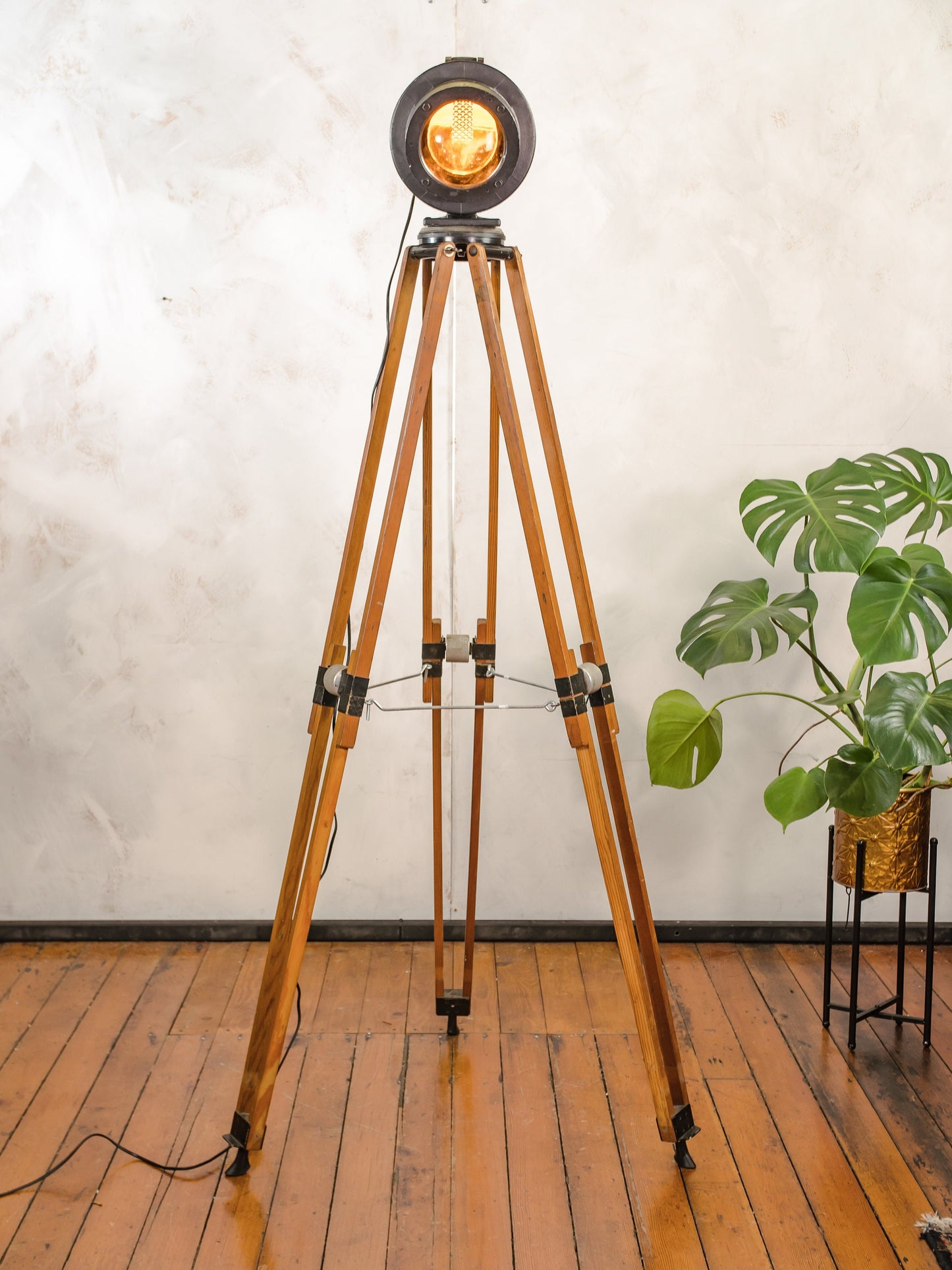 Zwarte spoorweg vloerlamp uit de jaren 50, hergebruikt signaallicht op een vintage houten videografiestatief, industriële staande lamp