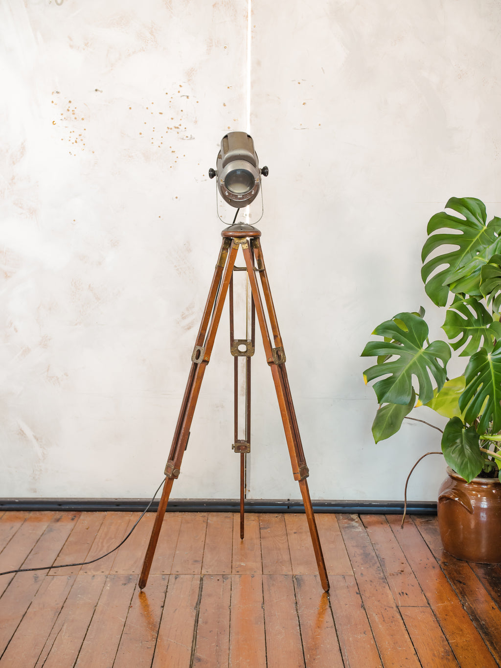 Antieke Franse theaterlamp spotllight, staande vloerlamp uit de jaren 1950, A.E. Cremer Paris Baby Spot op een antiek Eastman Kodak statief.