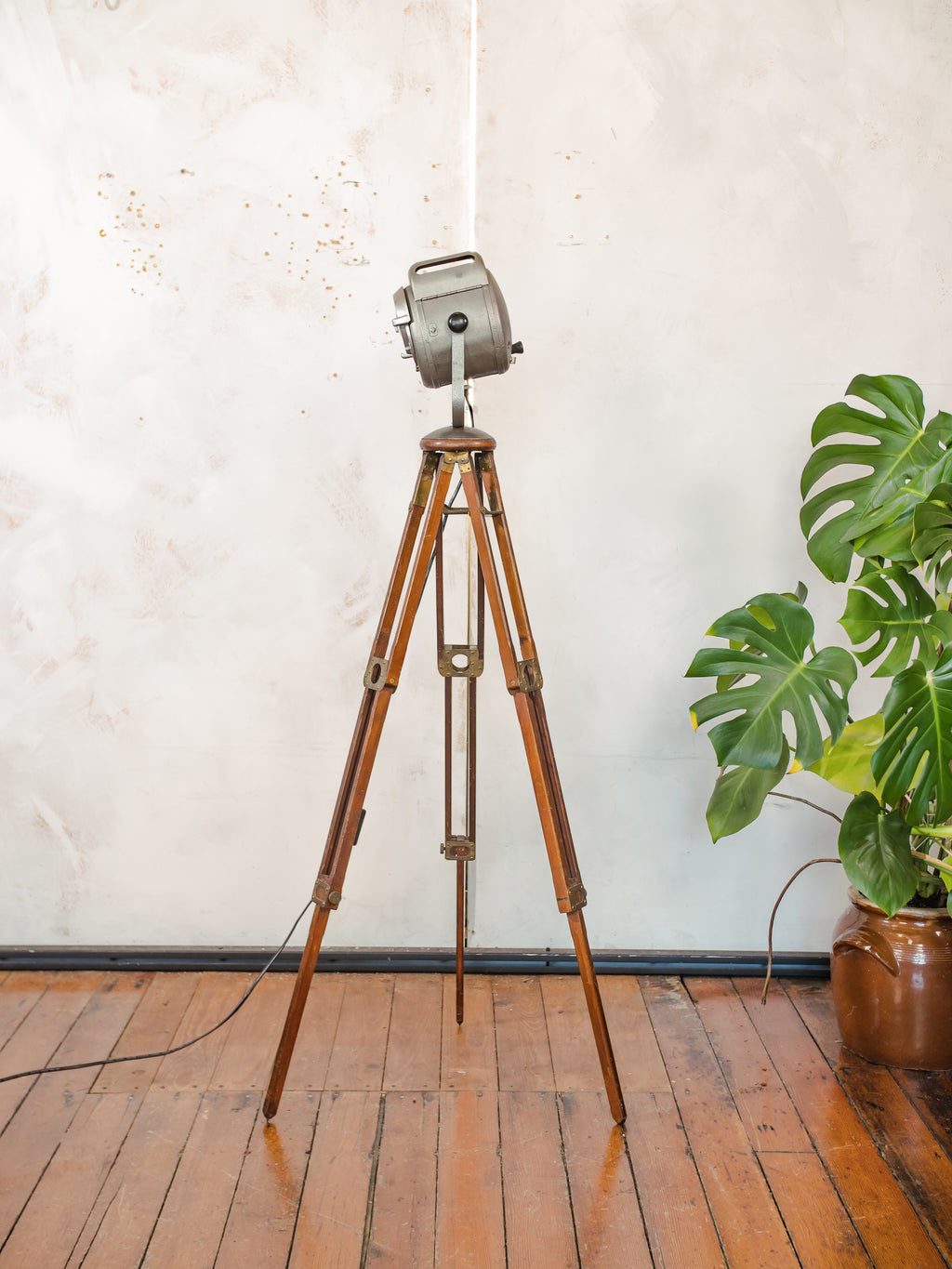 Antieke Franse theaterlamp spotllight, staande vloerlamp uit de jaren 1950, A.E. Cremer Paris Baby Spot op een antiek Eastman Kodak statief.