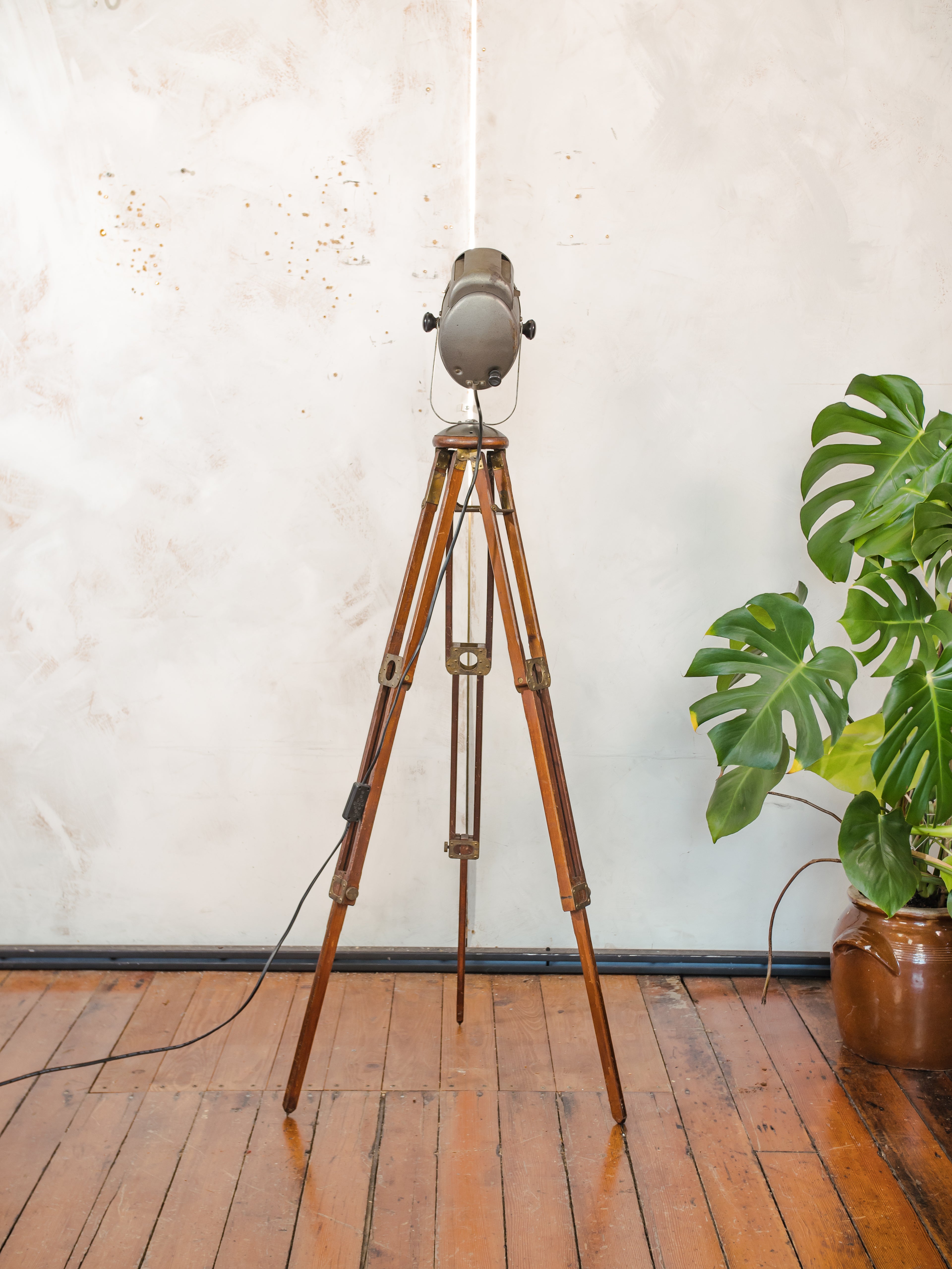 Antieke Franse theaterlamp spotllight, staande vloerlamp uit de jaren 1950, A.E. Cremer Paris Baby Spot op een antiek Eastman Kodak statief.