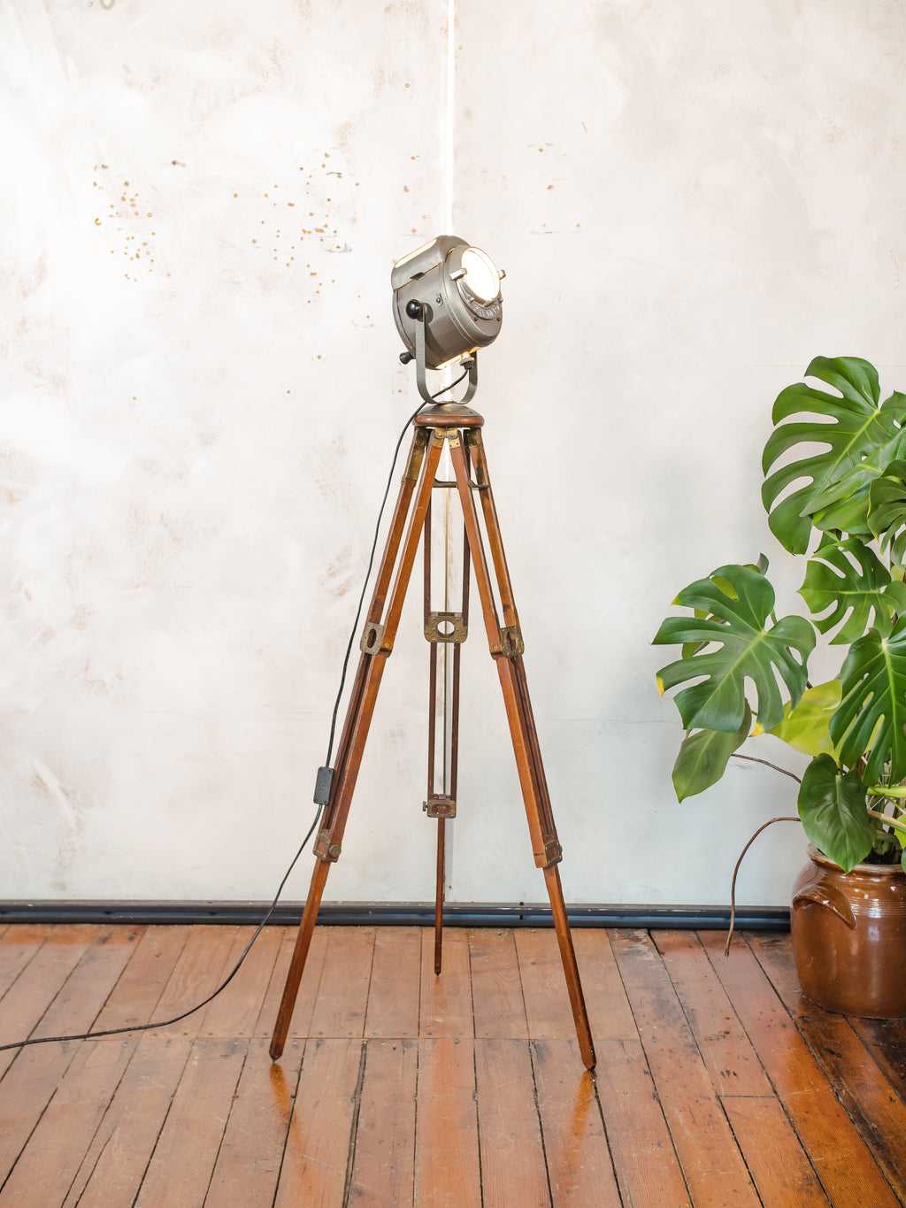 Antieke Franse theaterlamp spotllight, staande vloerlamp uit de jaren 1950, A.E. Cremer Paris Baby Spot op een antiek Eastman Kodak statief.