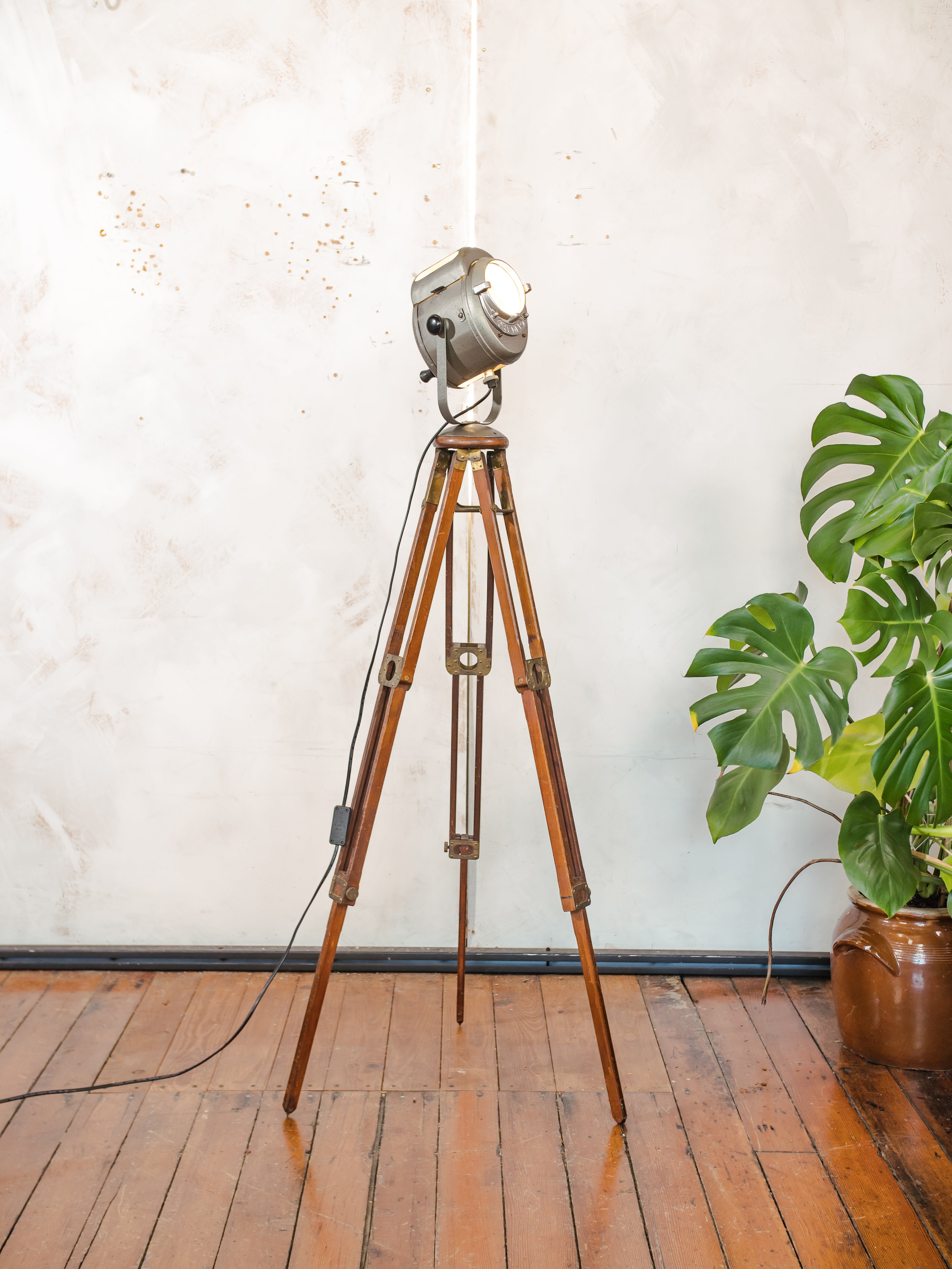 Antieke Franse theaterlamp spotllight, staande vloerlamp uit de jaren 1950, A.E. Cremer Paris Baby Spot op een antiek Eastman Kodak statief.