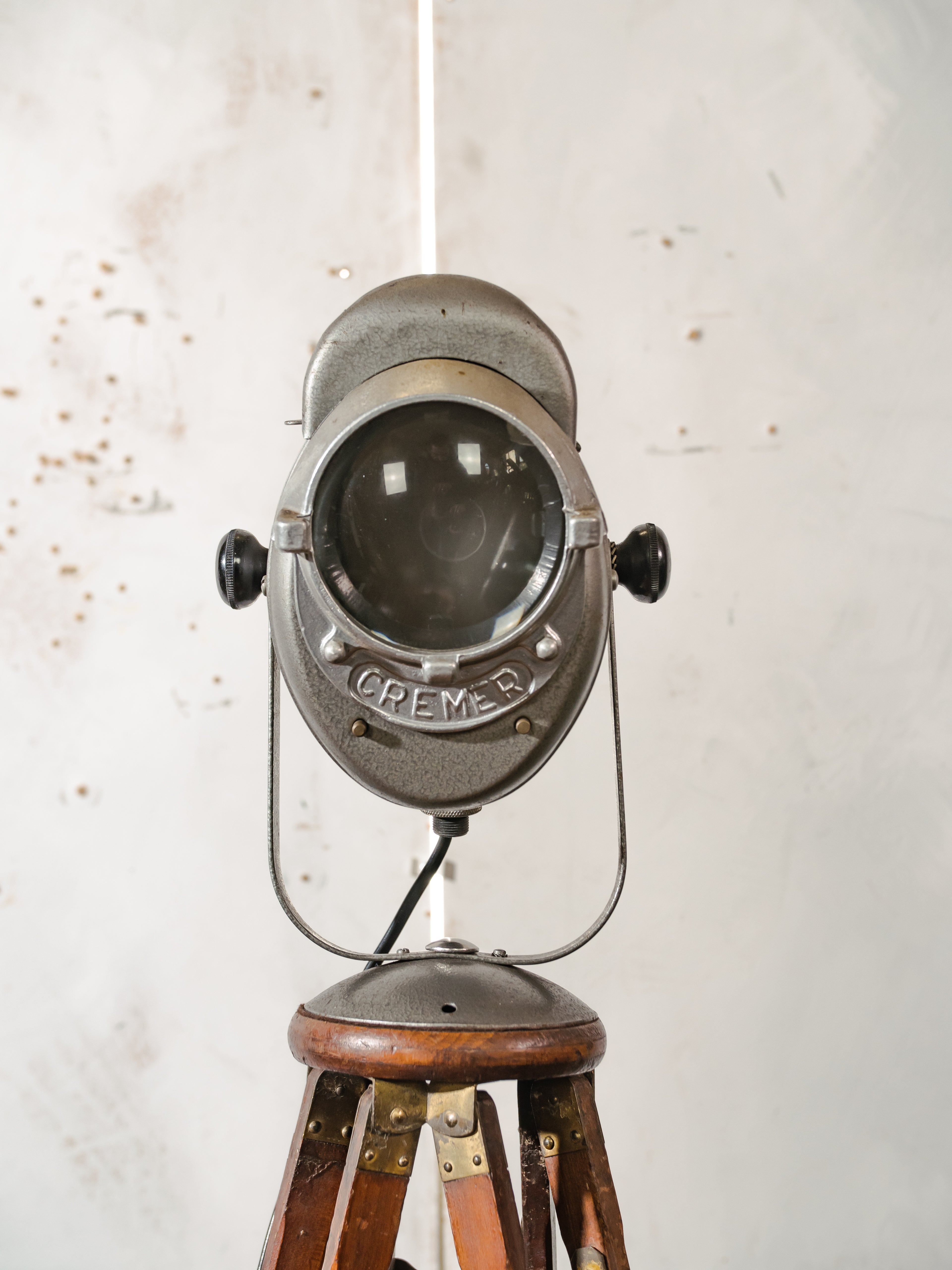 Antieke Franse theaterlamp spotllight, staande vloerlamp uit de jaren 1950, A.E. Cremer Paris Baby Spot op een antiek Eastman Kodak statief.