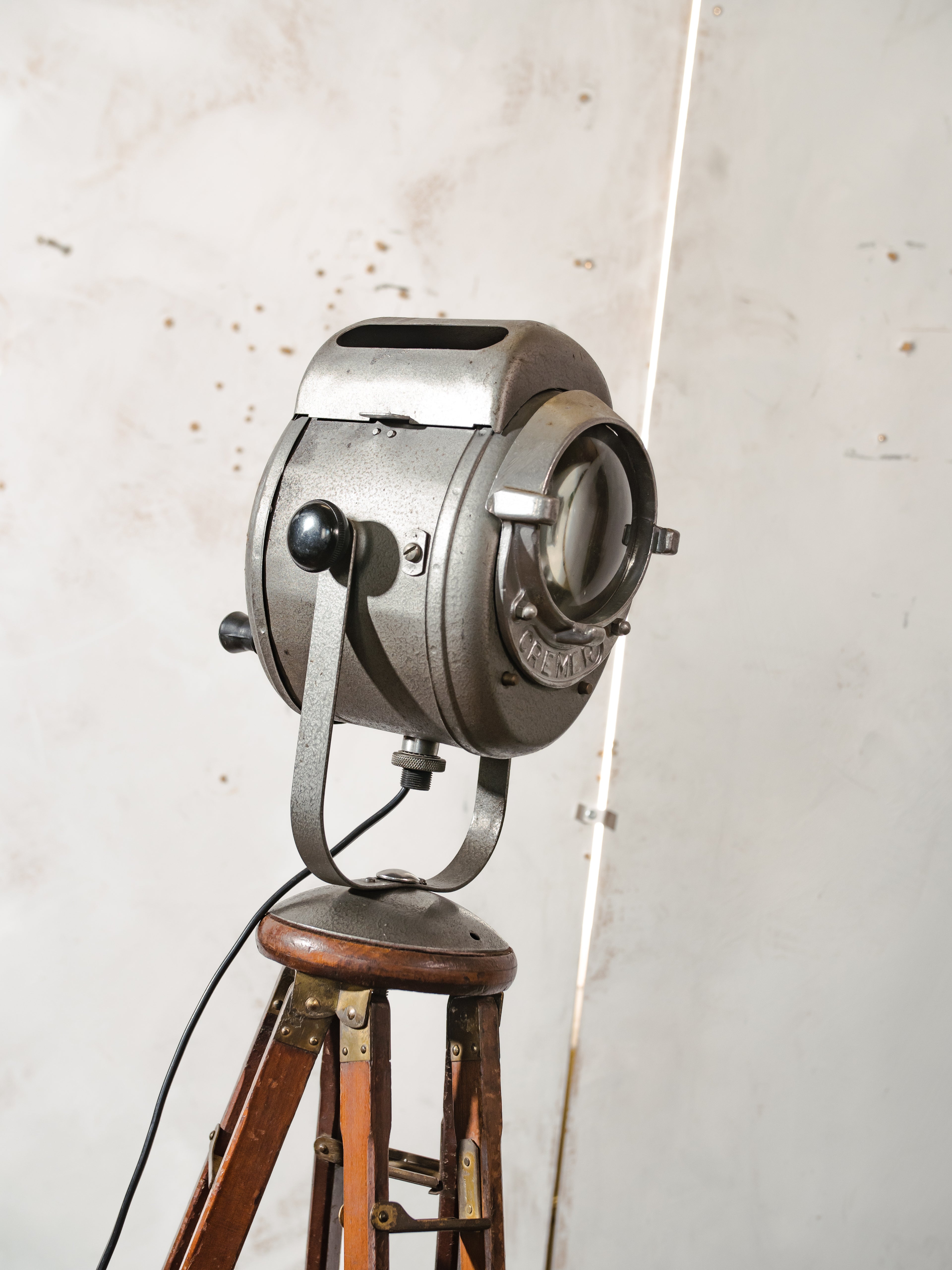 Antieke Franse theaterlamp spotllight, staande vloerlamp uit de jaren 1950, A.E. Cremer Paris Baby Spot op een antiek Eastman Kodak statief.