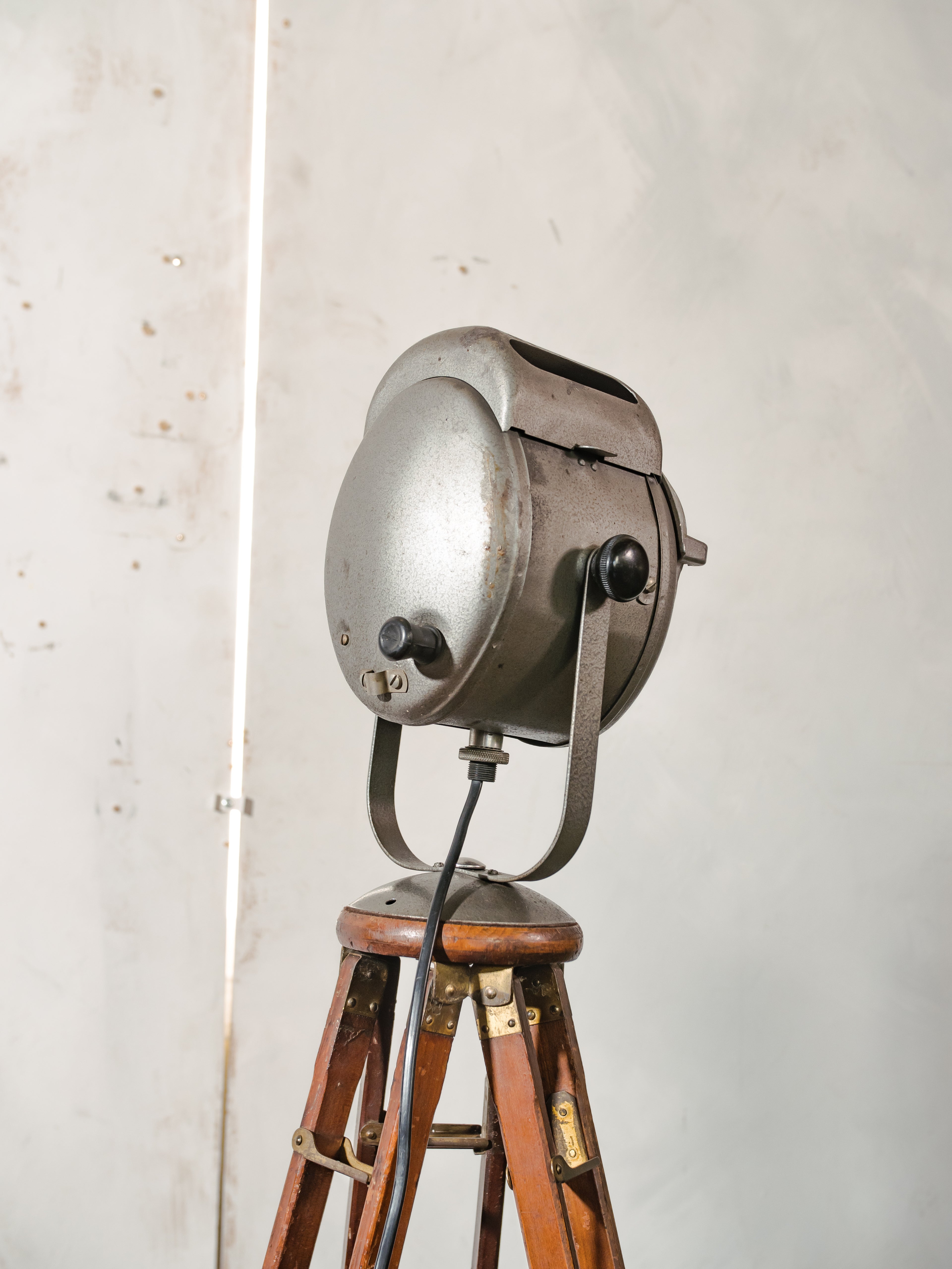 Antieke Franse theaterlamp spotllight, staande vloerlamp uit de jaren 1950, A.E. Cremer Paris Baby Spot op een antiek Eastman Kodak statief.