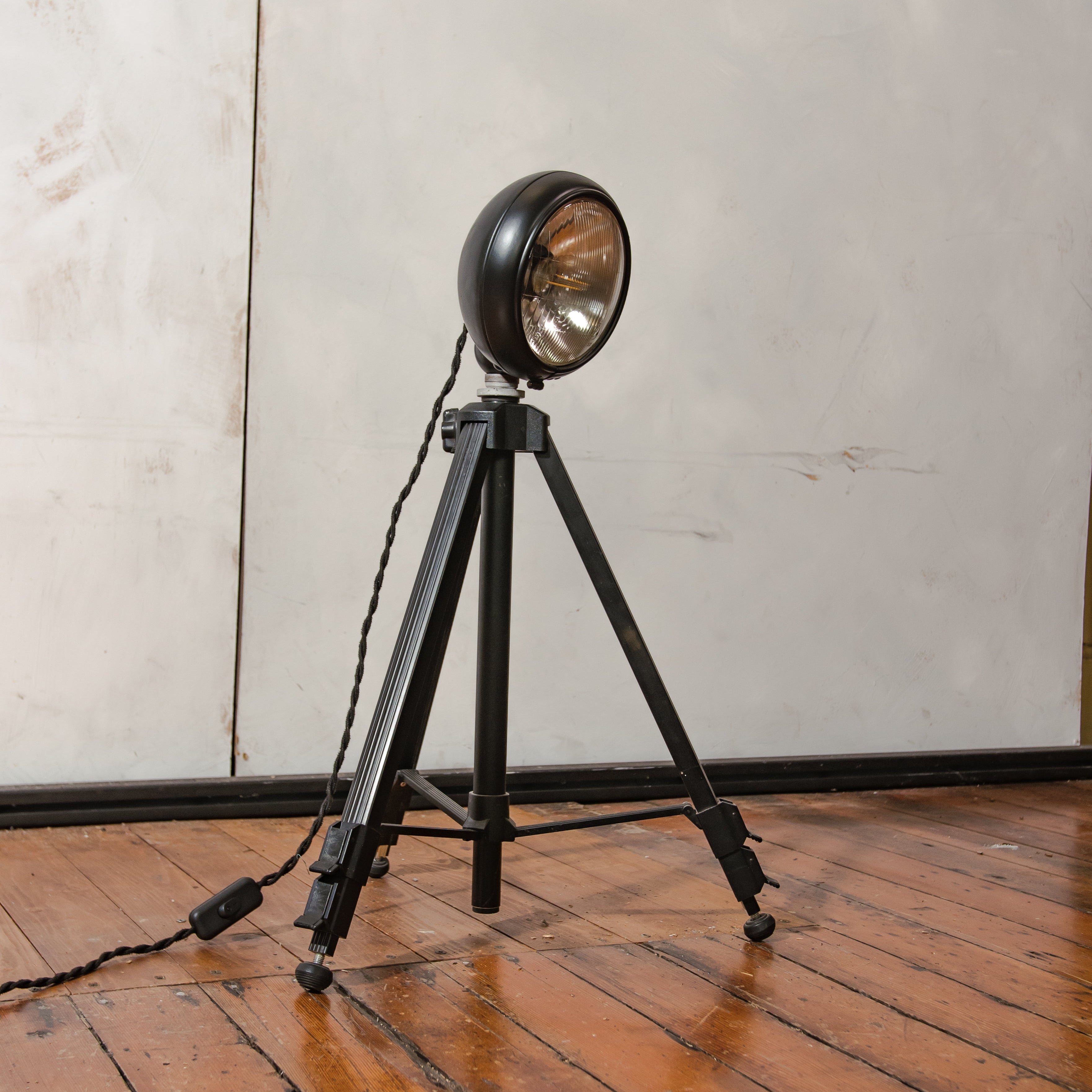 Vintage zwarte tafellamp automotive koplamp op een fotografie statief, verstelbaar tot vloerlamp, spotlight lamp.