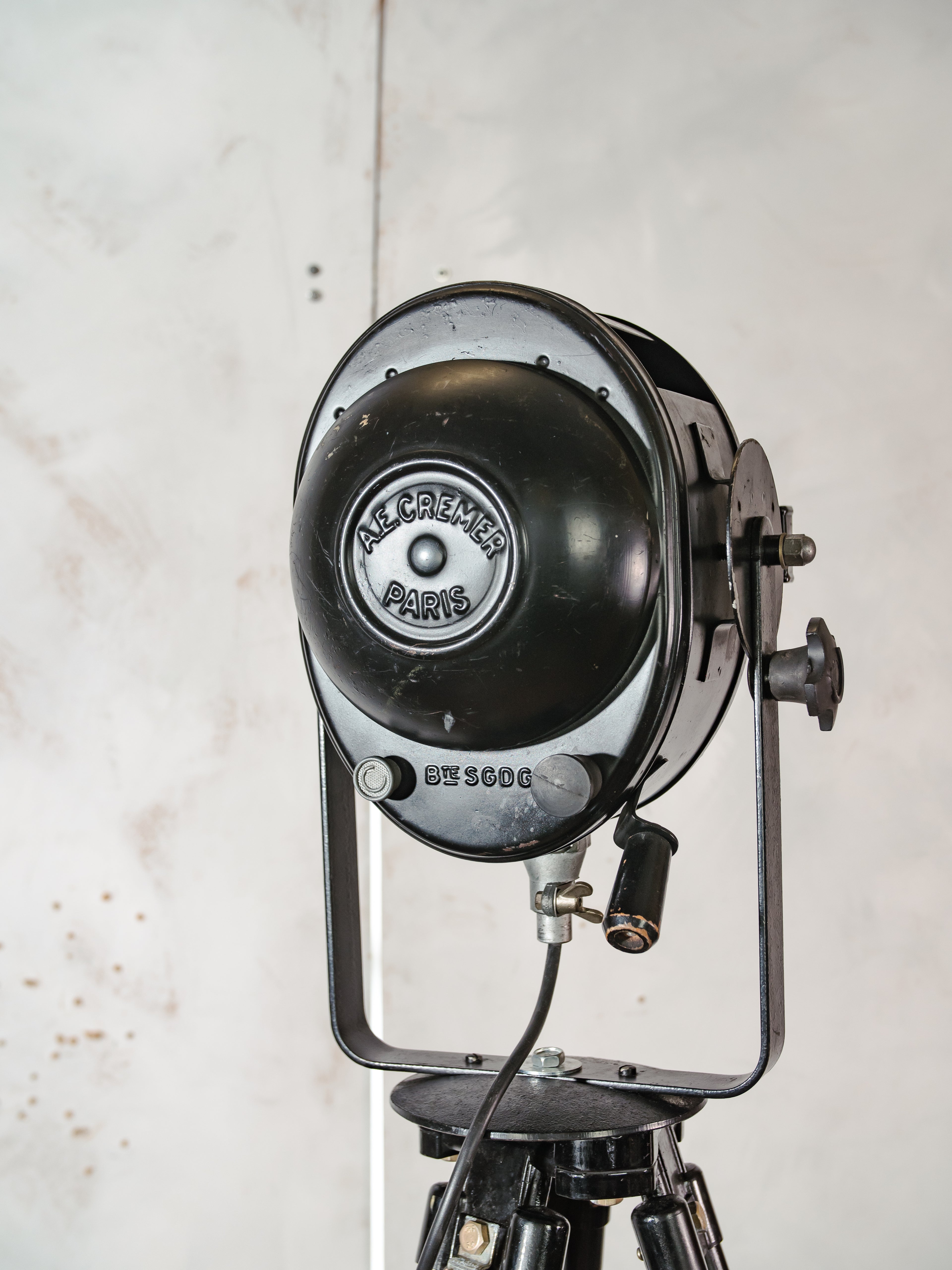 1950s Black A.E. Cremer Paris Industrial Film Spotlight Floor lamp, Mounted on Wooden Surveying Tripod, French Antique Spotlight