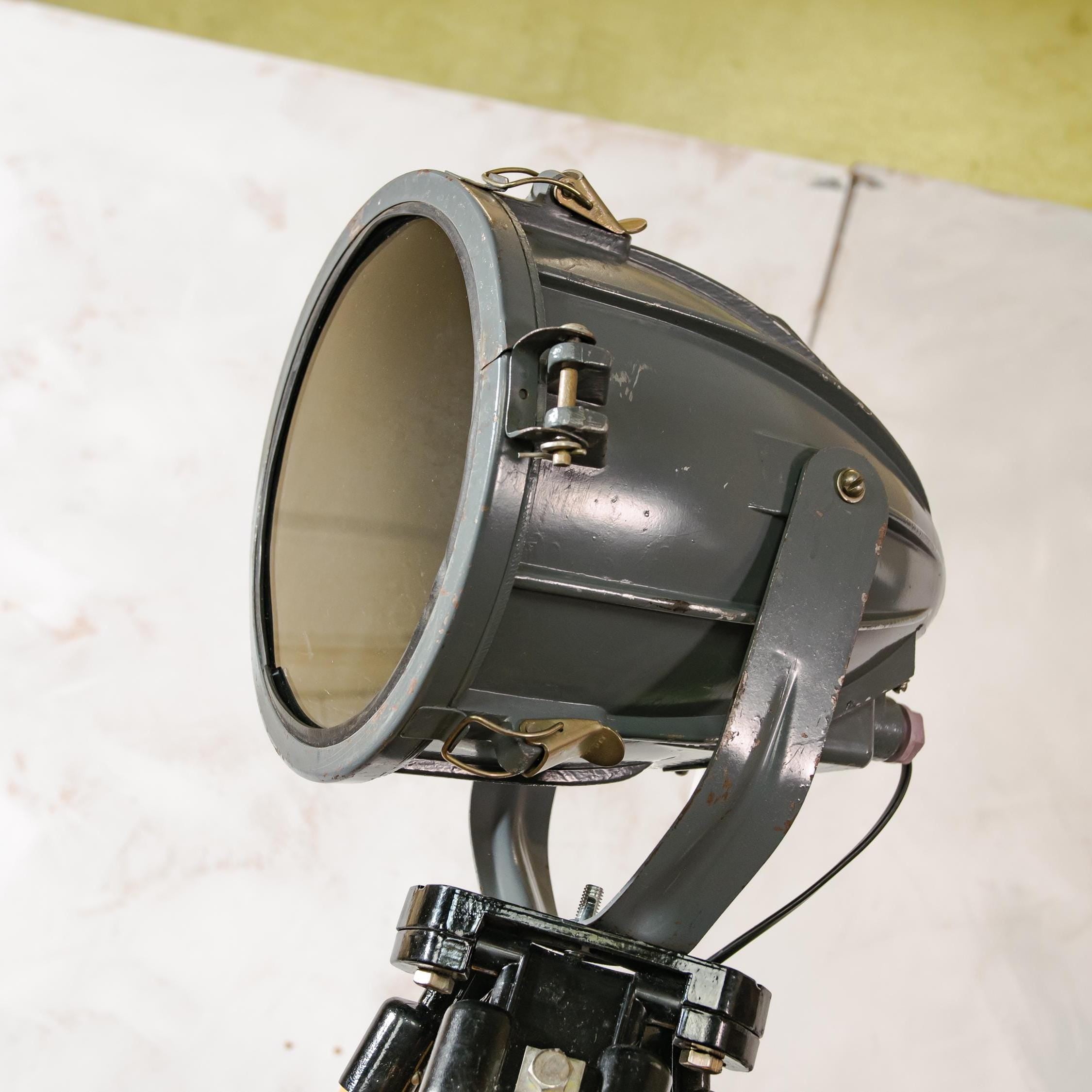 Donkergrijze Sovjet-spot uit de jaren 70 op een landmeetkundige driepoot, industriële vloerlamp in raketvorm, vintage reflectorprojectorlamp