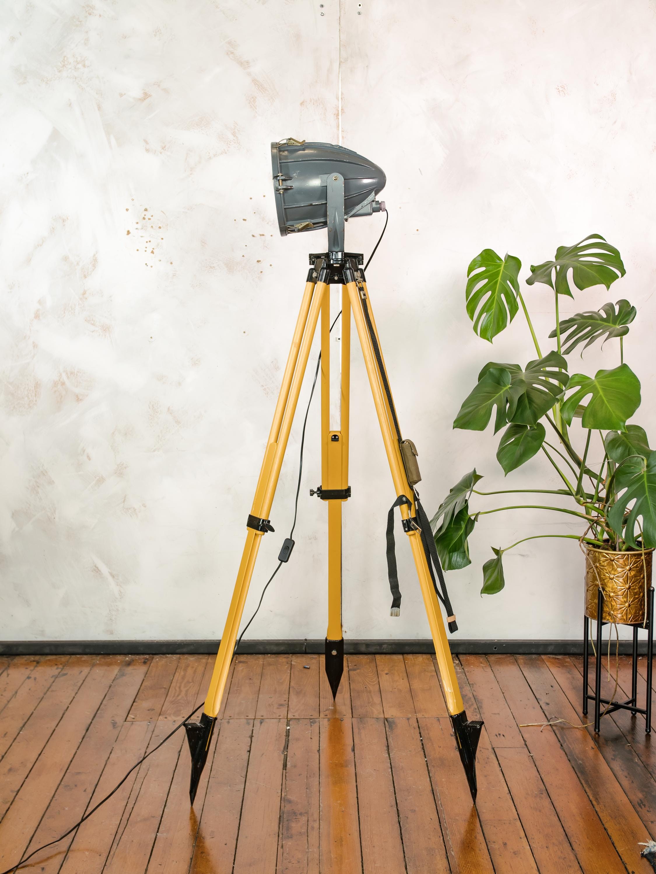 Donkergrijze Sovjet-spot uit de jaren 70 op een landmeetkundige driepoot, industriële vloerlamp in raketvorm, vintage reflectorprojectorlamp