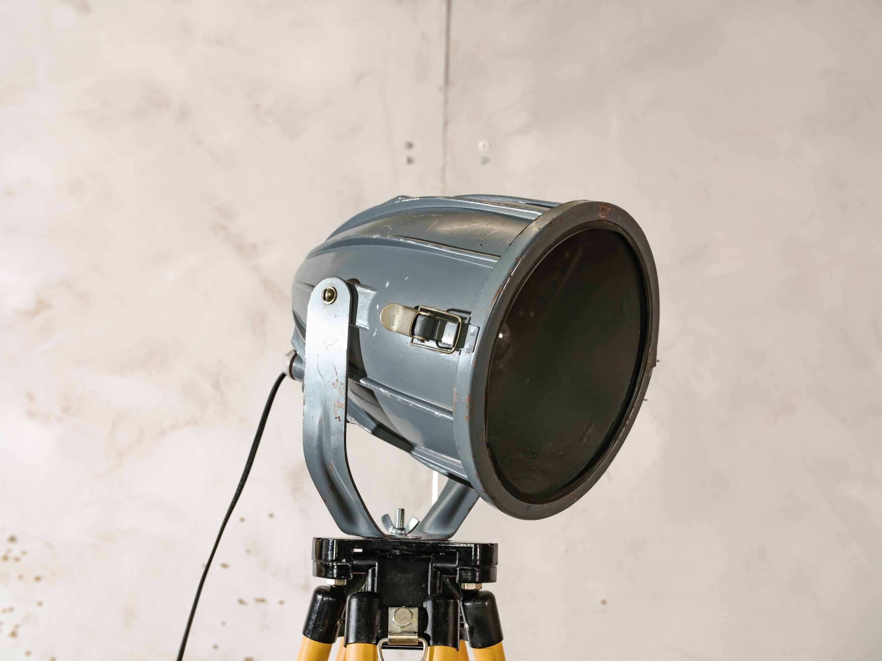 Donkergrijze Sovjet-spot uit de jaren 70 op een landmeetkundige driepoot, industriële vloerlamp in raketvorm, vintage reflectorprojectorlamp